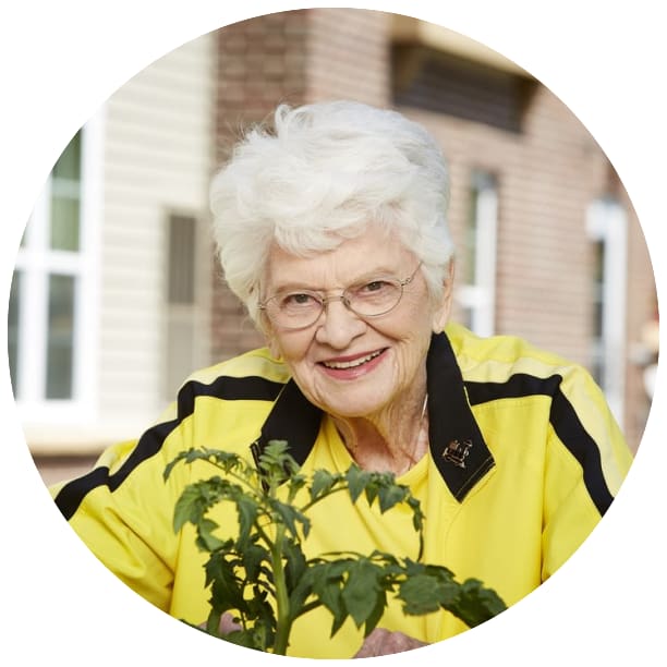 Resident planting flowers outside at Wildwood Manor Apartments