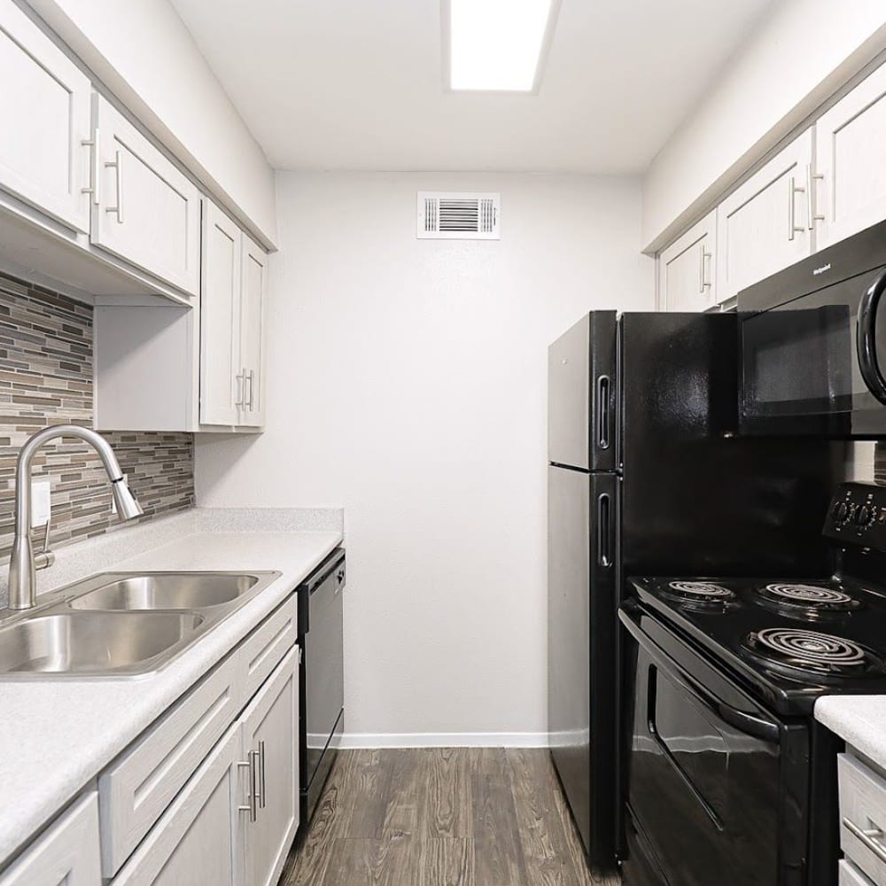 Bright kitchen with tiled backsplash at Silvermine in Victoria, Texas