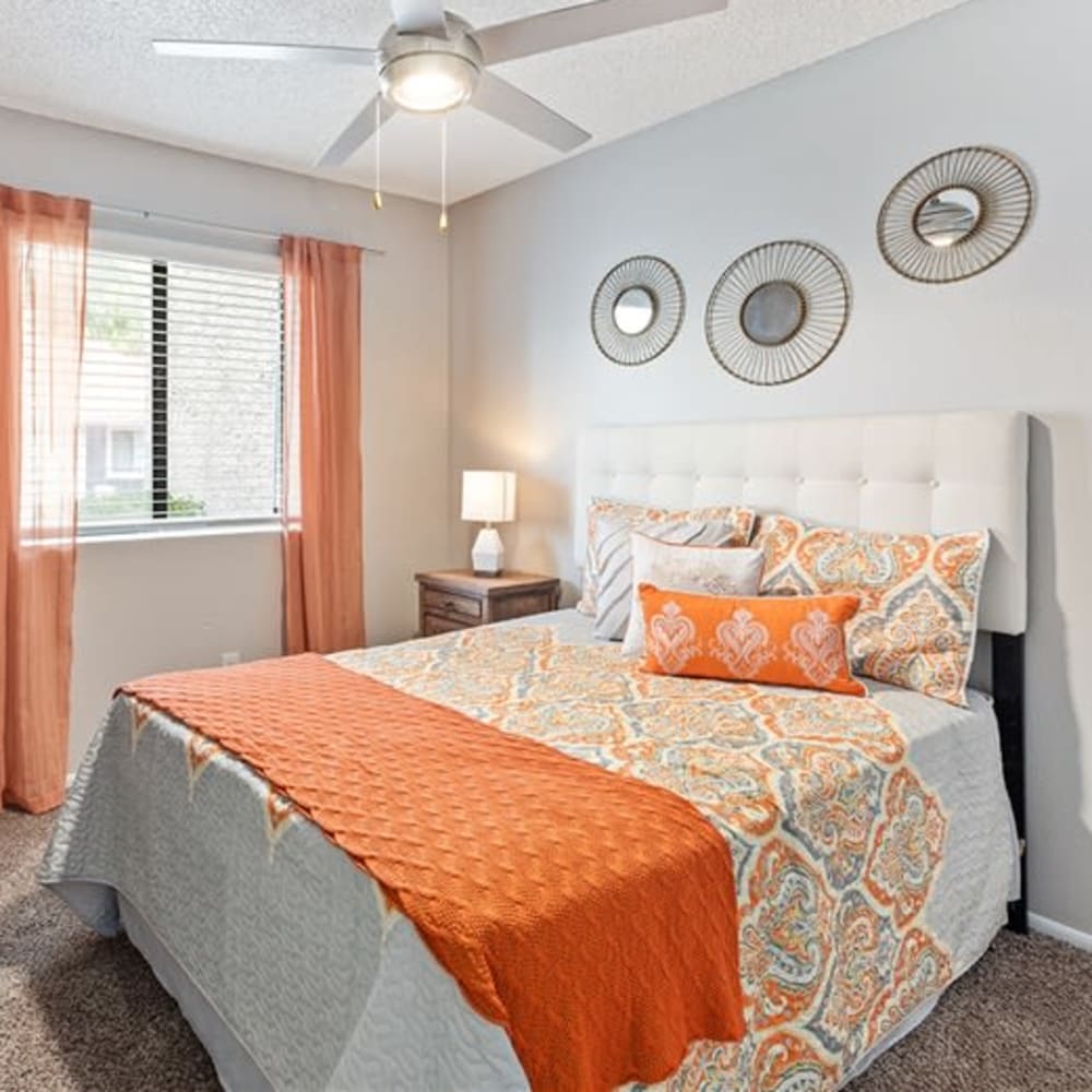 A bedroom with plush carpeting and a ceiling fan at Argenta Apartments in Mesa, Arizona
