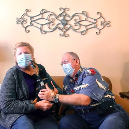 Resident couple in their apartment with their cute dog of Oxford Glen Memory Care at Carrollton in Carrollton, Texas