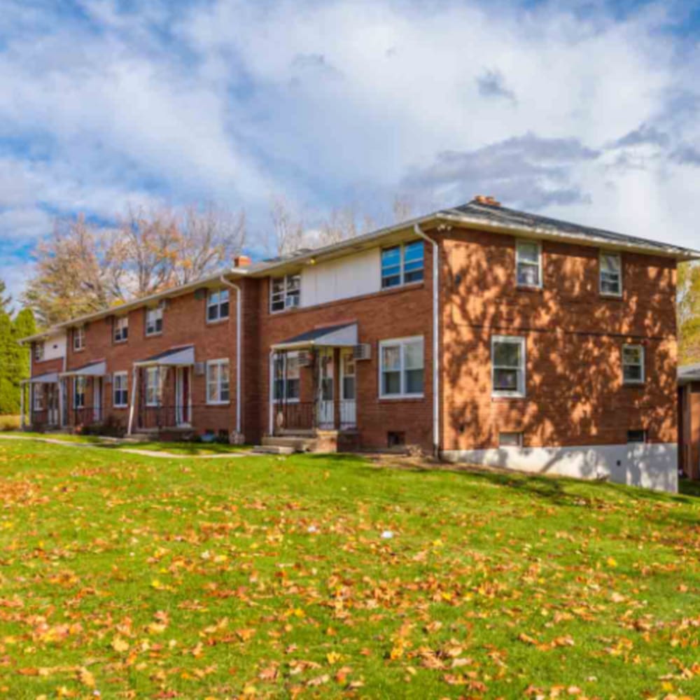 Brick apartment buildings with grassy lawn at 4500 Dewey Ave Apartments in Rochester, New York 
