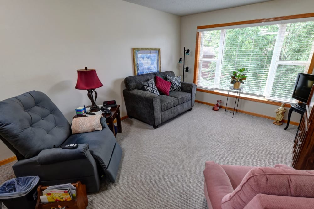 Comfortable living room with large windows at Garnett Place in Cedar Rapids, Iowa