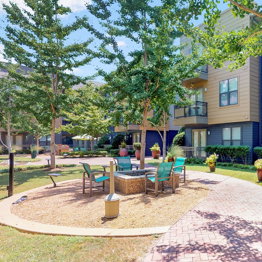 Fire pit area surrounded by comfortable seating at Oaks 5th Street Crossing at City Station in Garland, Texas