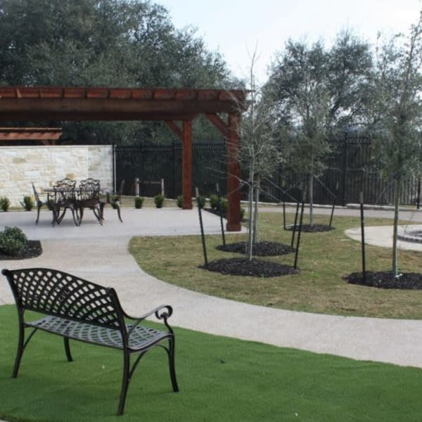 Fenced courtyard with patches of grass at Quail Park of Granbury in Granbury, Texas