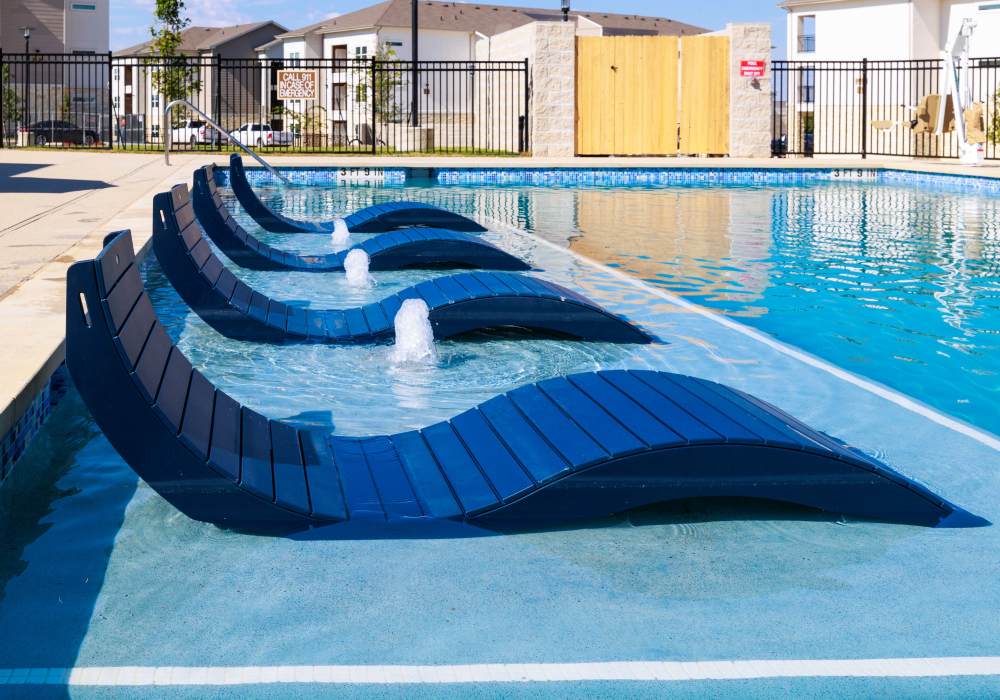 Resort-style pool with lounge chairs at Redwood in San Marcos, Texas