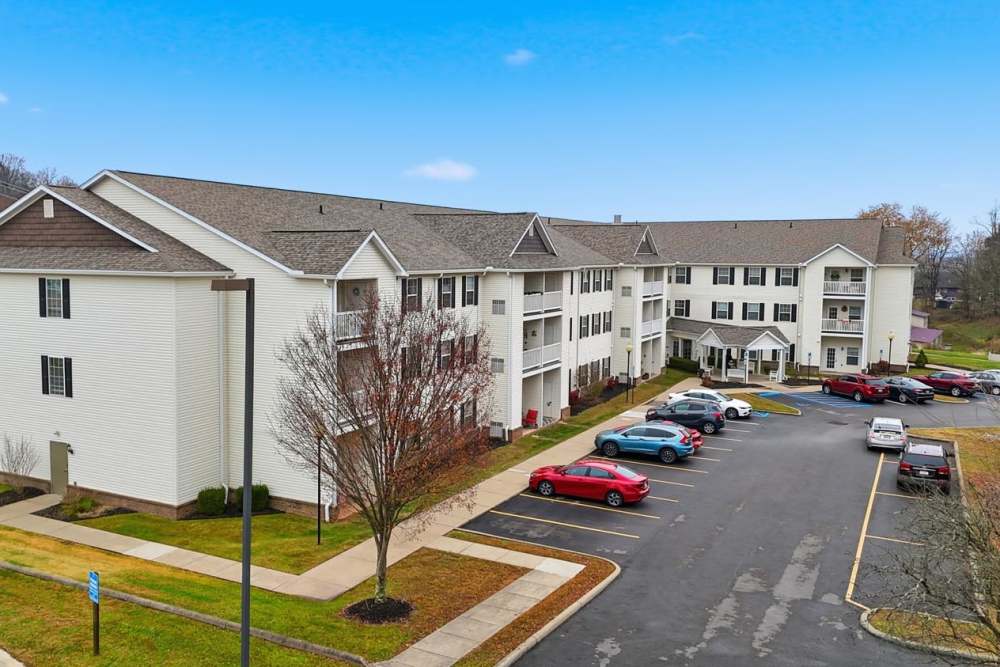 Modern apartment community with spacious parking lot and landscaped pathways at Norwood Greene Senior Living in Marietta, Ohio