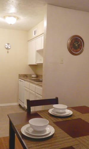 Dining area and kitchen of a model apartment home with hardwood-style floors at Parkway Villas in Grand Prairie, Texas