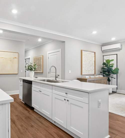 Modern kitchen with white cabinetry, stainless steel appliances, and wood-style flooring at Everett at Port Wentworth in Port Wentworth, Georgia