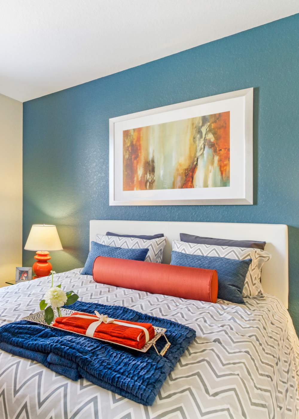 New blue blanket on bed with orange towels at Commonwealth Landing Lofts in Fall River, Massachusetts