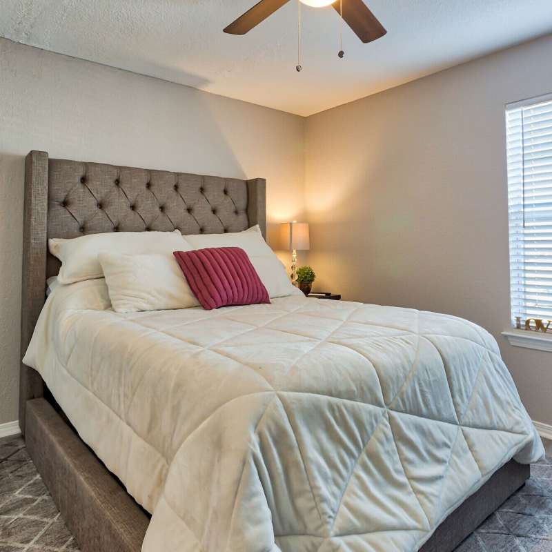 Spacious bedroom with windows and ceiling fan at The Gardens At Duncan Apartments in Duncan, Oklahoma