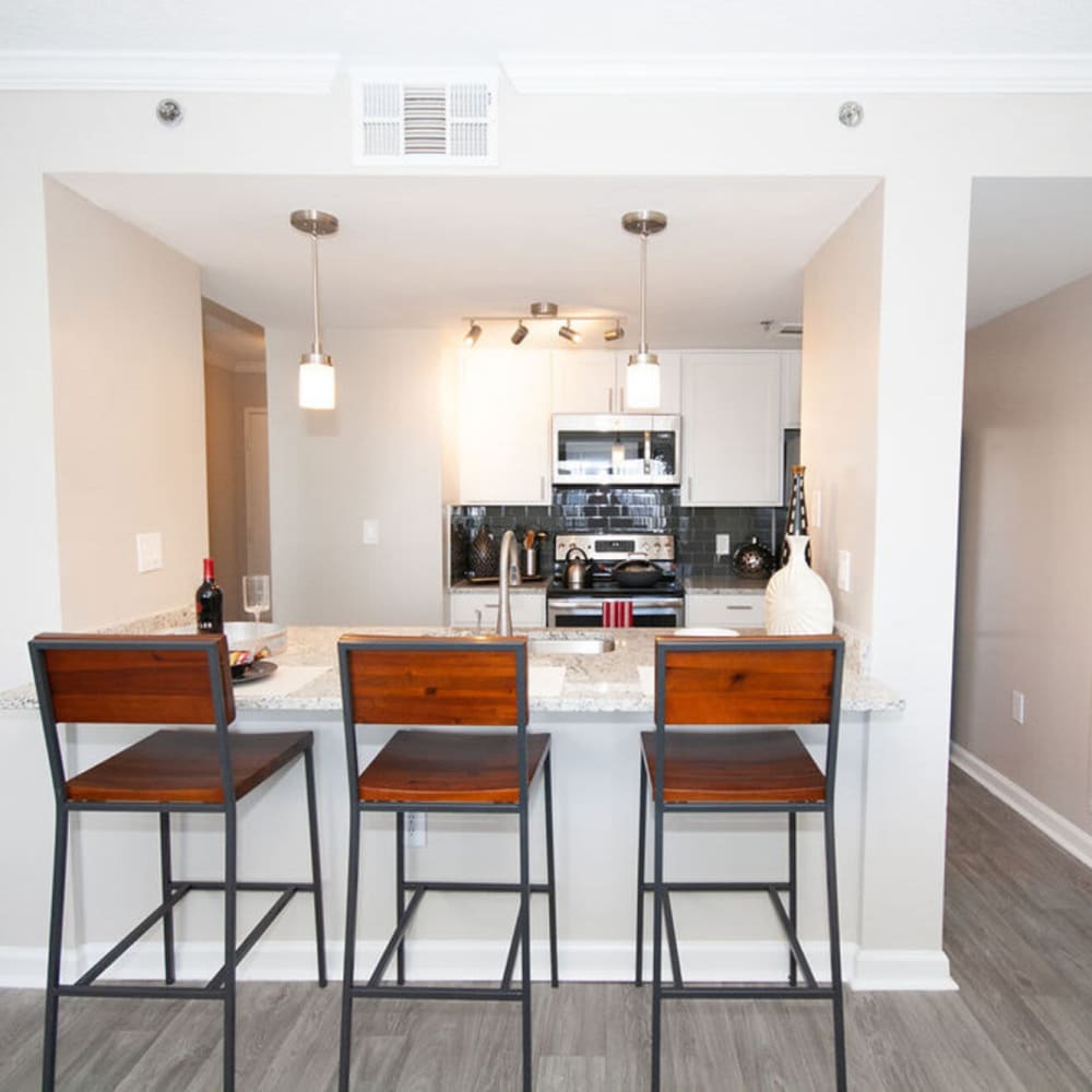 Kitchen with barstool and granite countertop at The Eva in Sandy Springs, Georgia