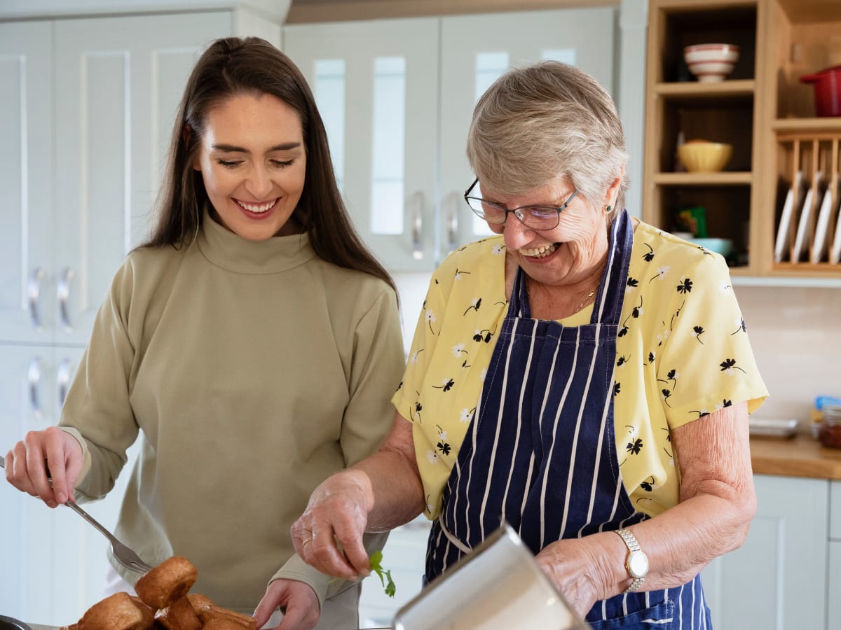 A resident and her daughter cooking at CERTUS Premier Memory Care Living in Orange City, Florida.