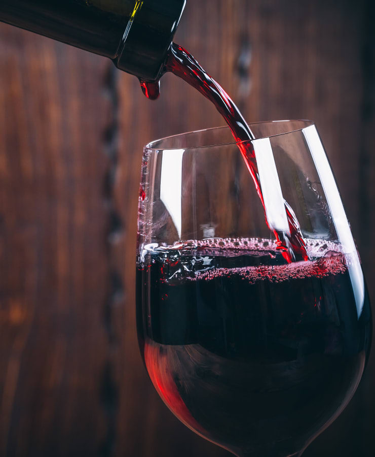 Close shot of a red wine being poured into a glass, near Collection 55 Cellars in Redwood City, California