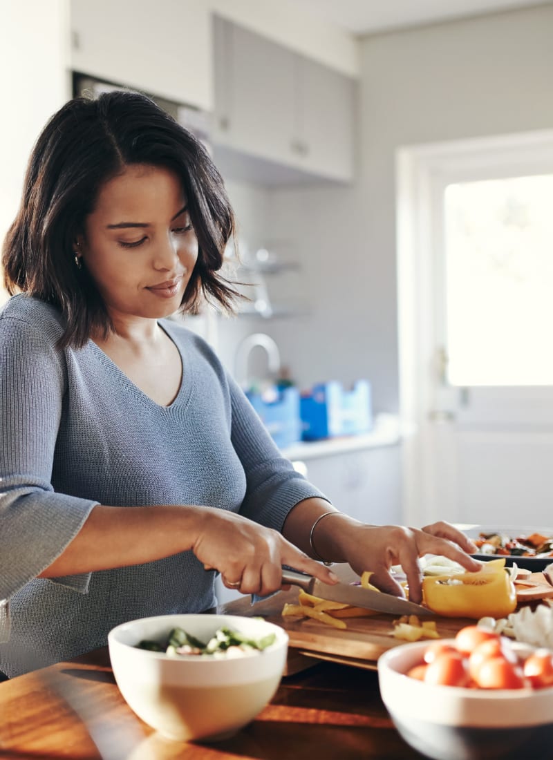 Resident cutting vegetables for meal prep at Marquis on Park Row in Houston, Texas