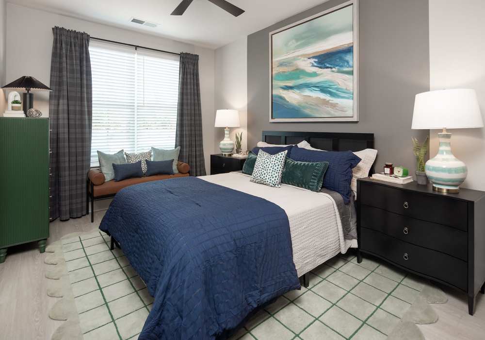 Modern bedroom with expansive windows, spacious closet, and stylish ceiling fan at Cypress Point in Mooresville, North Carolina.