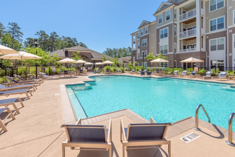Resort-style swimming pool flanked by chaise lounge chairs and lush vegetation at Sterling Town Center in Raleigh, North Carolina