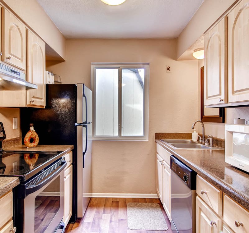 Spacious kitchen with wood-style plank flooring at Arvada Green Apartment Homes in Arvada, Colorado
