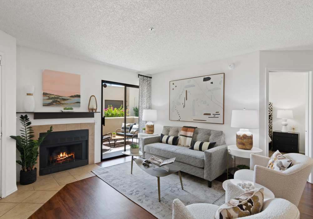 Stylish living room with large sofa and in-home fireplace at Casa Santa Fe Apartments in Scottsdale, Arizona