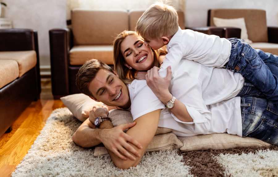 Family playing together on living room floor at Redwood in San Marcos, Texas