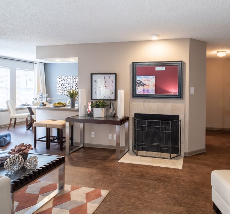 Open-concept model home with wood-style flooring and a fireplace at Ridgeview Place in Irving, Texas