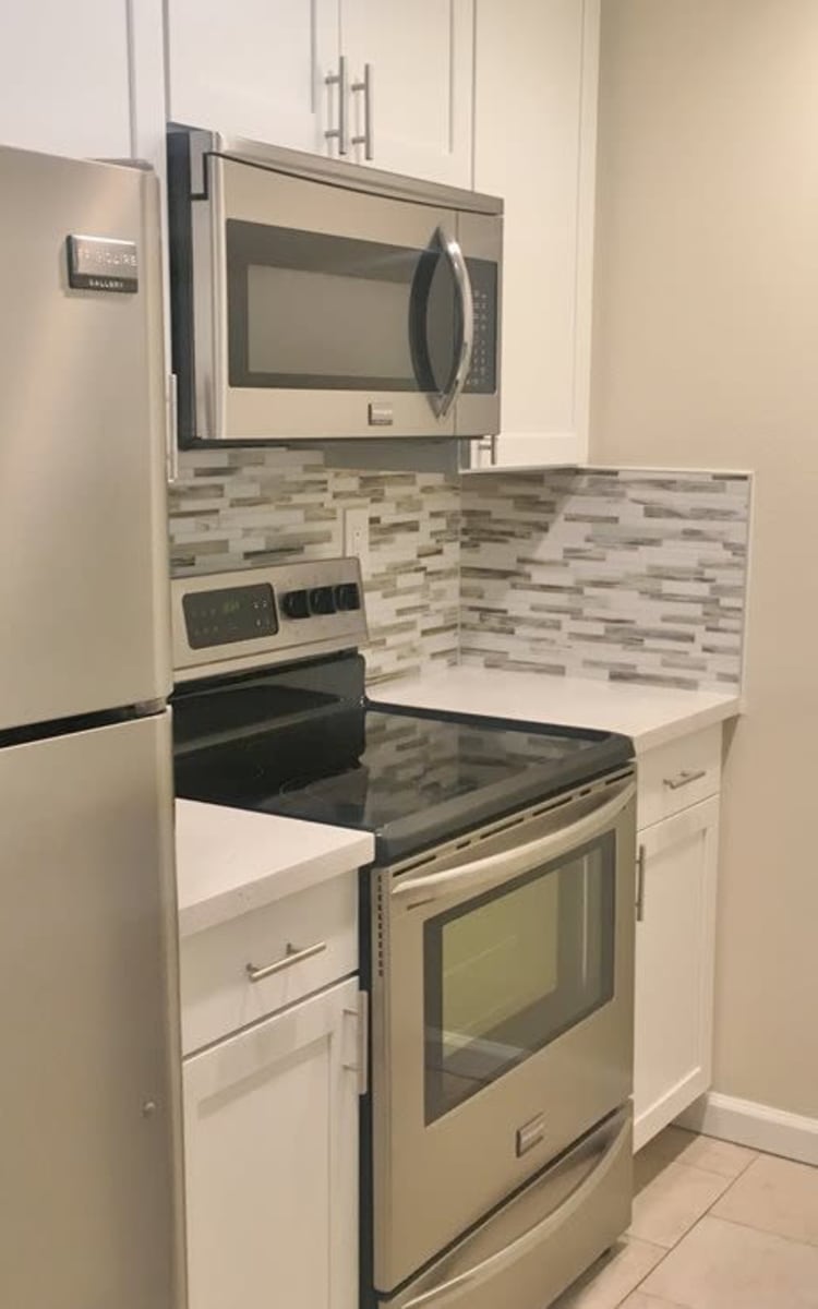Kitchen with white cabinetry and stainless-steel appliances at Haven Warner Center in Canoga Park, California