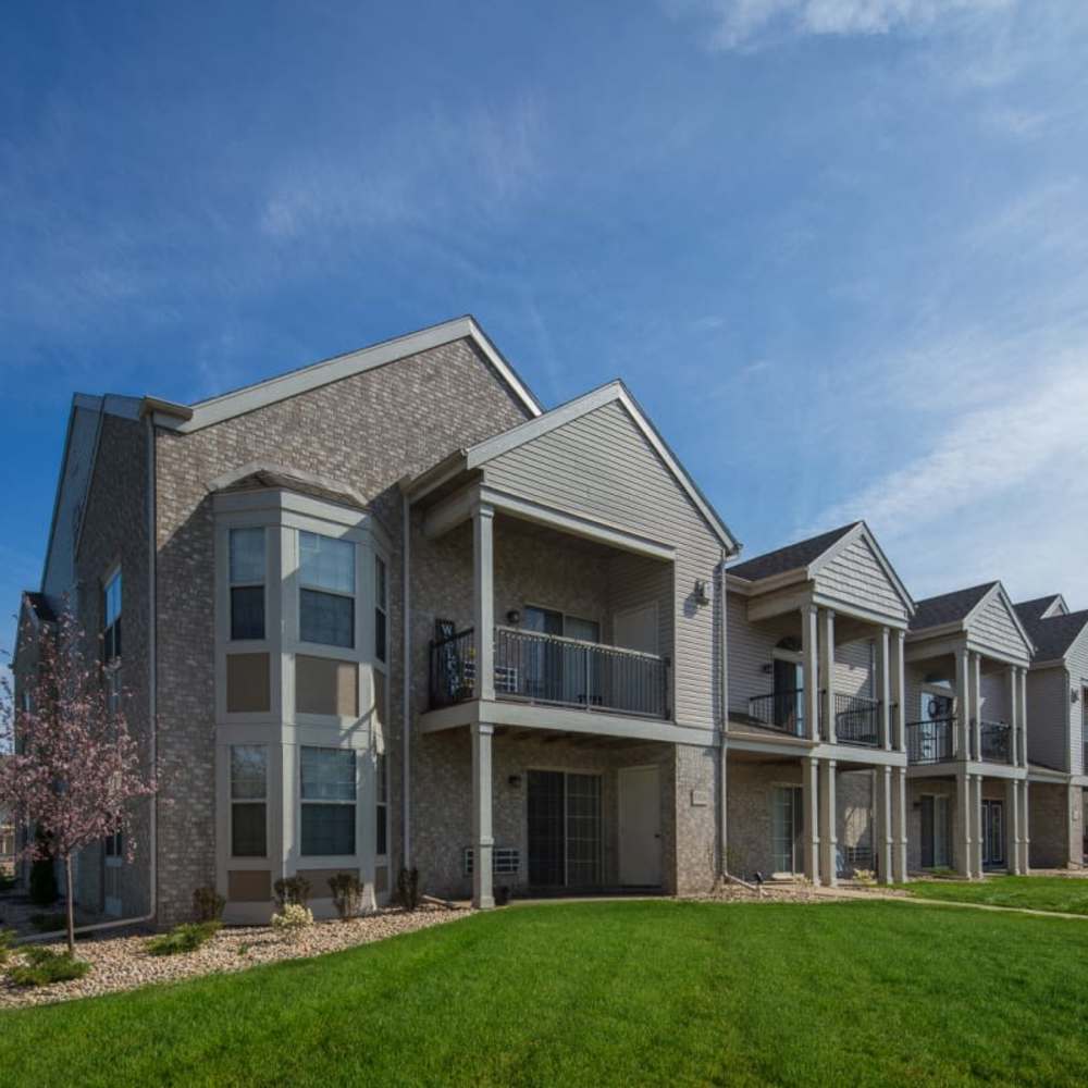 Charming exterior with lush landscaping and inviting balconies at Lake Pointe Apartments in Madison, Wisconsin.