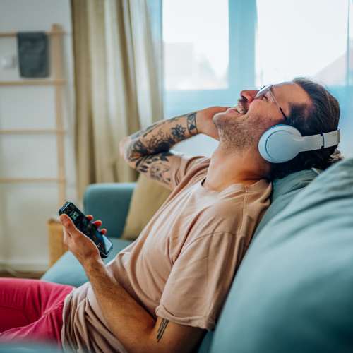 Resident listening to music in his living room at One Belmar Place in Lakewood, Colorado