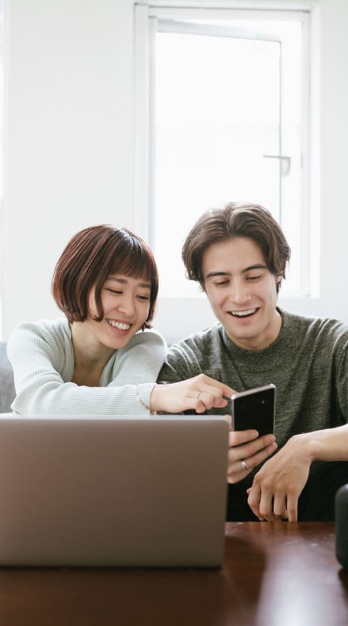 A couple looking at benefits packages on a laptop at Liberty Military Housing in Newport Beach, California