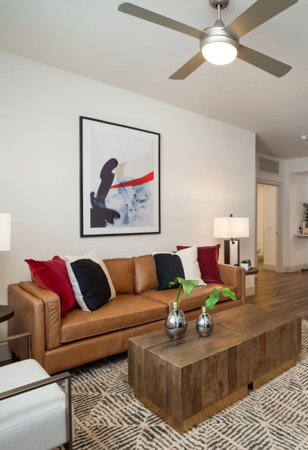 Sleek style living room with large windows and wood flooring at Marquis at Chandler in Chandler, Arizona