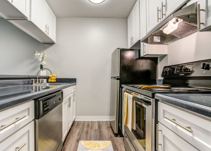White renovated Kitchen with stainless steel appliances at The Timbers Apartments in Hayward, CA