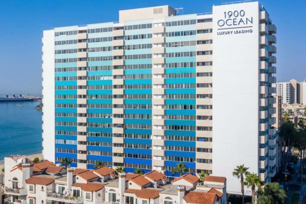 Beautiful property exterior with ocean theme colors and a property signage at 1900 Ocean Apartment Homes in Long Beach,California