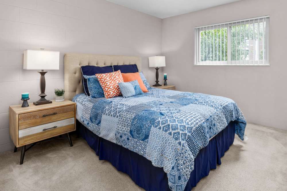 Bedroom with side lamp and window at West End Terrace Apartments in St. Louis, Missouri