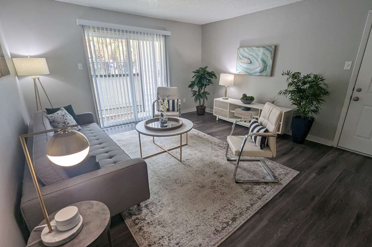 Charming living area at Sangria Park in Austin, Texas featuring modern furnishings, lush greenery, and natural light streaming through sliding glass doors.