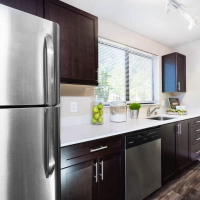 Modern kitchen with stainless-steel appliances in a model home at Madison Sammamish Apartments in Sammamish, Washington