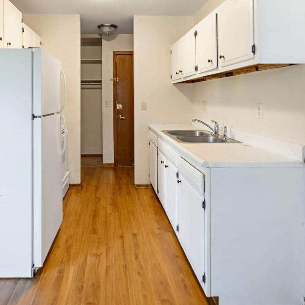 Kitchen with white appliances and hard-wood flooring at Solace on Lake Minnetonka in Spring Park, Minnesota