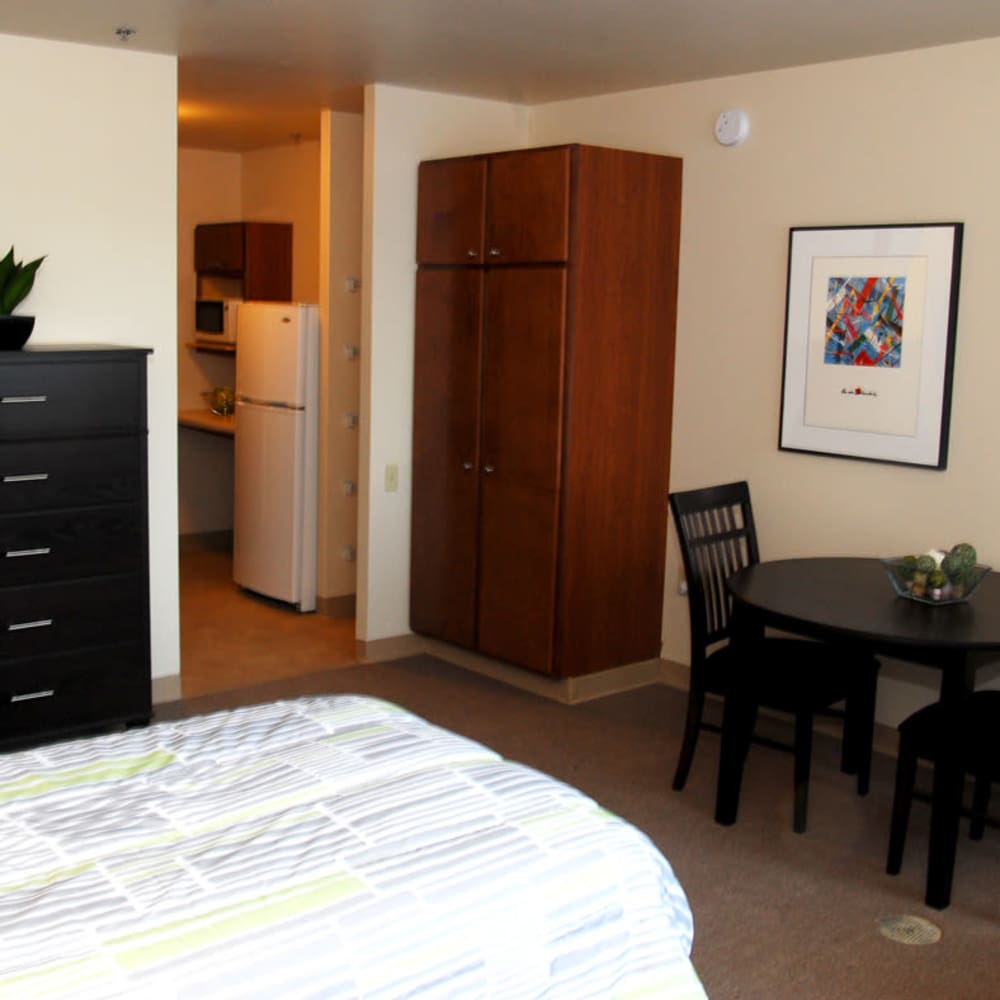 Bright bedroom with a wooden storage units and a table at Council Tower Apartments in Saint Louis,Missouri