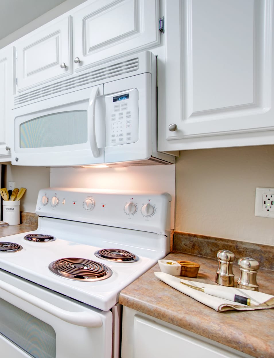 Kitchen with hardwood flooring and a pantry for additional storage in a model home at Waterstone Fremont in Fremont, California