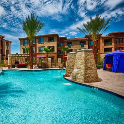 Resort-style swimming pool with private cabanas nearby at Elevation Chandler in Chandler, Arizona