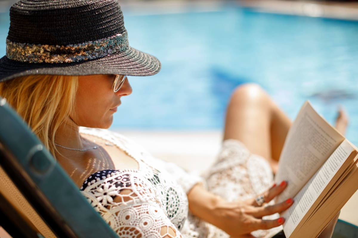 Reading by the pool at Midtown Manor and Towers in Bryan, Texas