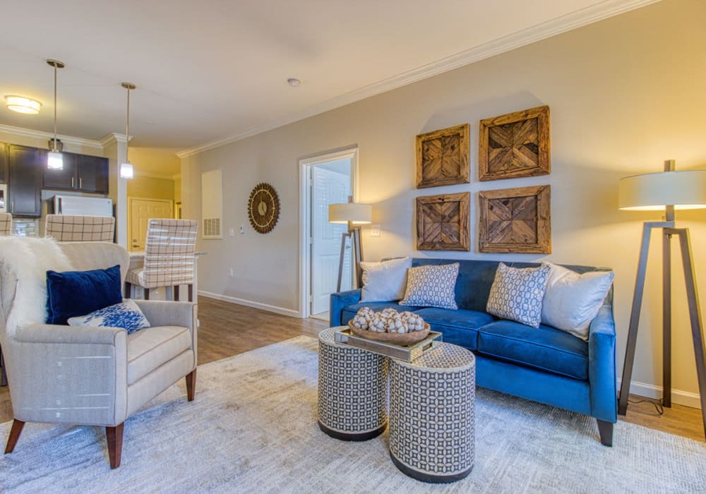 Great lighting in living room with hardwood-style flooring that connects to kitchen with island at Greymont Village in Asheville, North Carolina