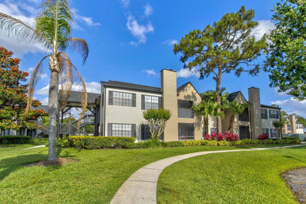 Apartment exterior with lawn and palm trees at Cypress Run in Orlando, Florida
