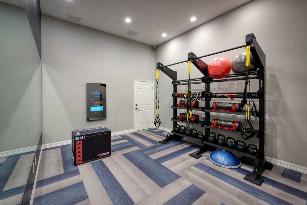 Community gym with various strength training equipment at Promenade at Hunter's Glen Apartments in Thornton, Colorado