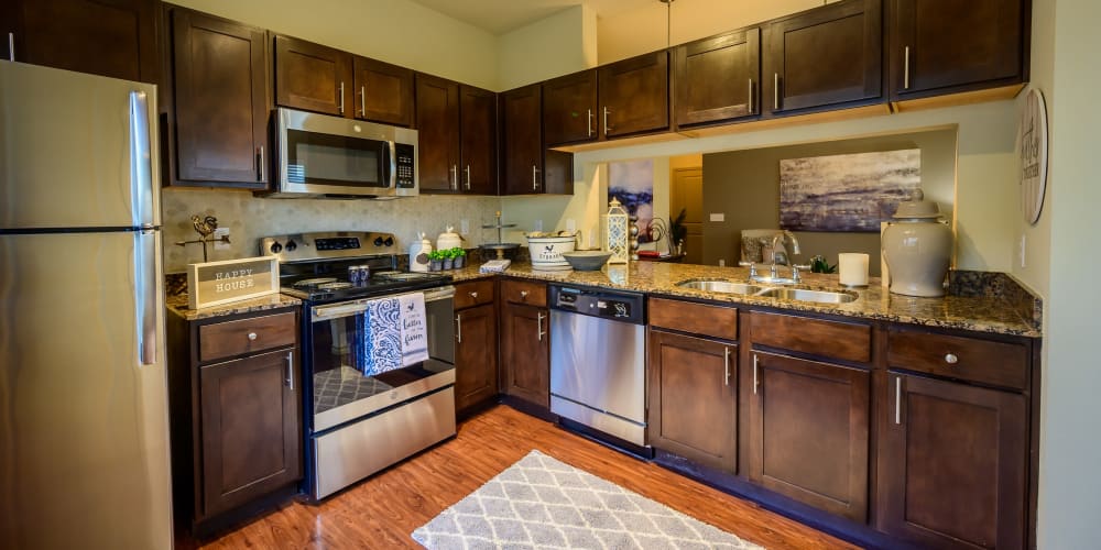 Dark wood cabinetry in model kitchen at Pecan Springs Apartments in San Antonio, Texas