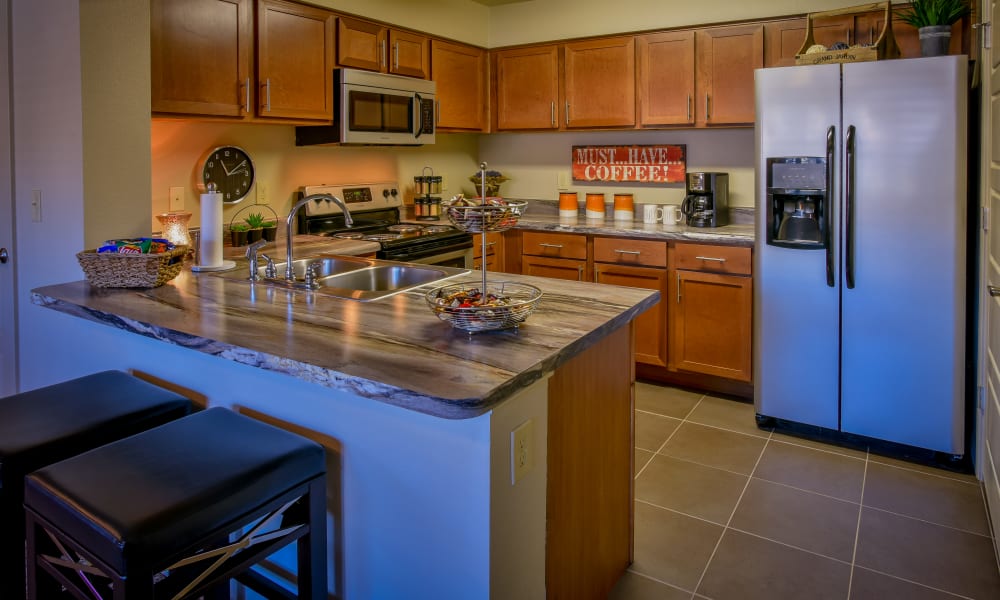 Spacious kitchen with granite countertops and light cabinetry at Icon at Broken Arrow in Broken Arrow, Oklahoma
