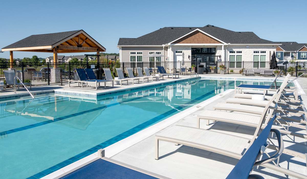 Saltwater pool with loungers and clubhouse view at Remington Lake Apartments in Hamilton, Ohio