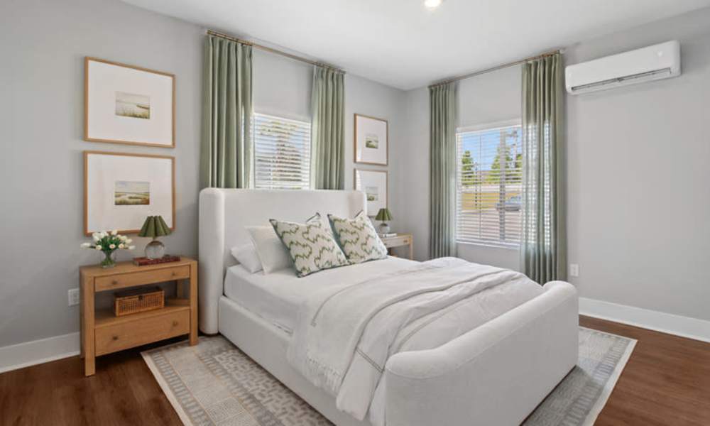 Cozy bedroom with wood-style flooring, queen bed, and large closet with mirrored doors at Everett at Port Wentworth in Port Wentworth, Georgia