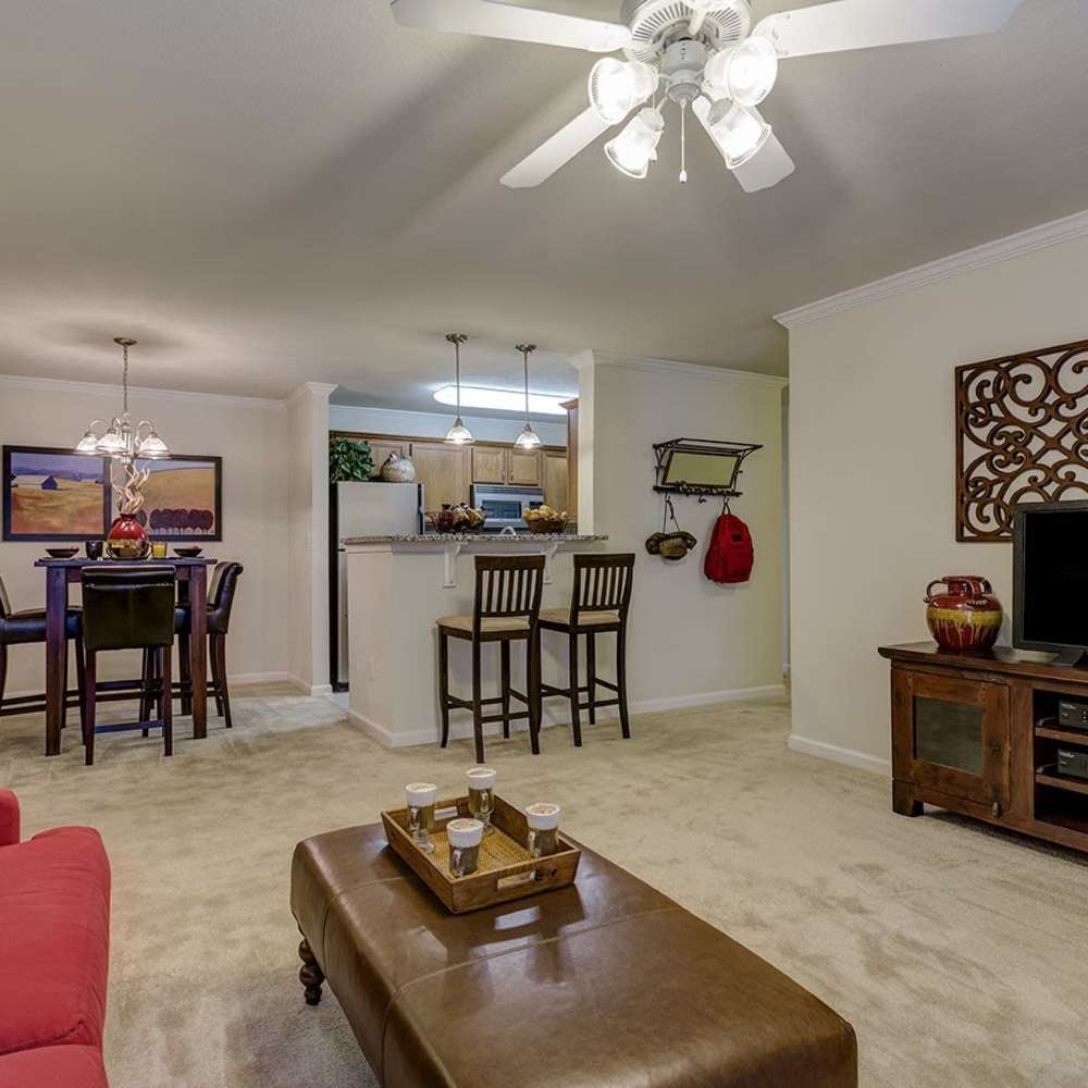 A furnished apartment living room with access to kitchen and dining area at Verandas at Mitylene in Montgomery, Alabama