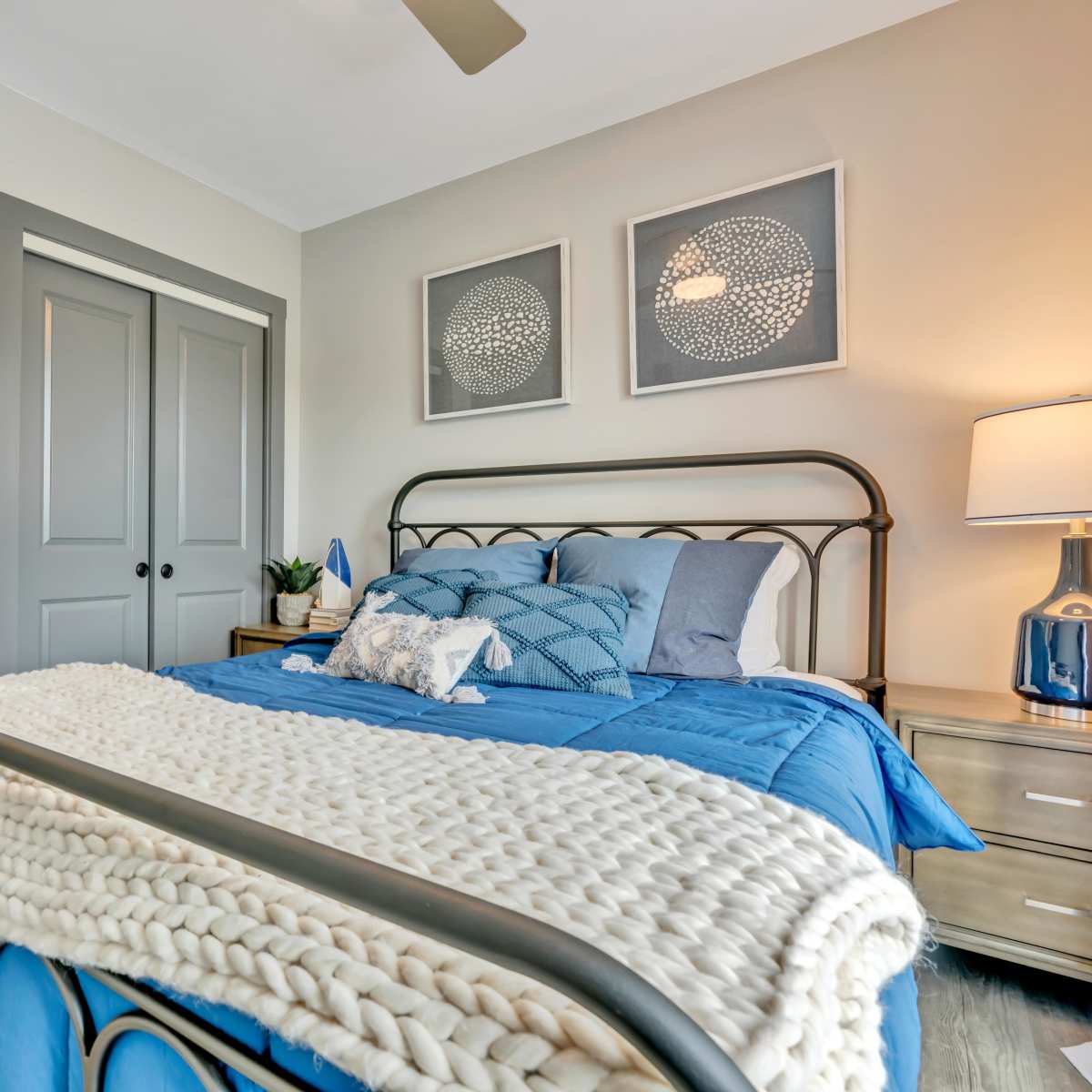 Bed with blue bedding and decorative pillows at Latitude at South Portland in Portland, Maine