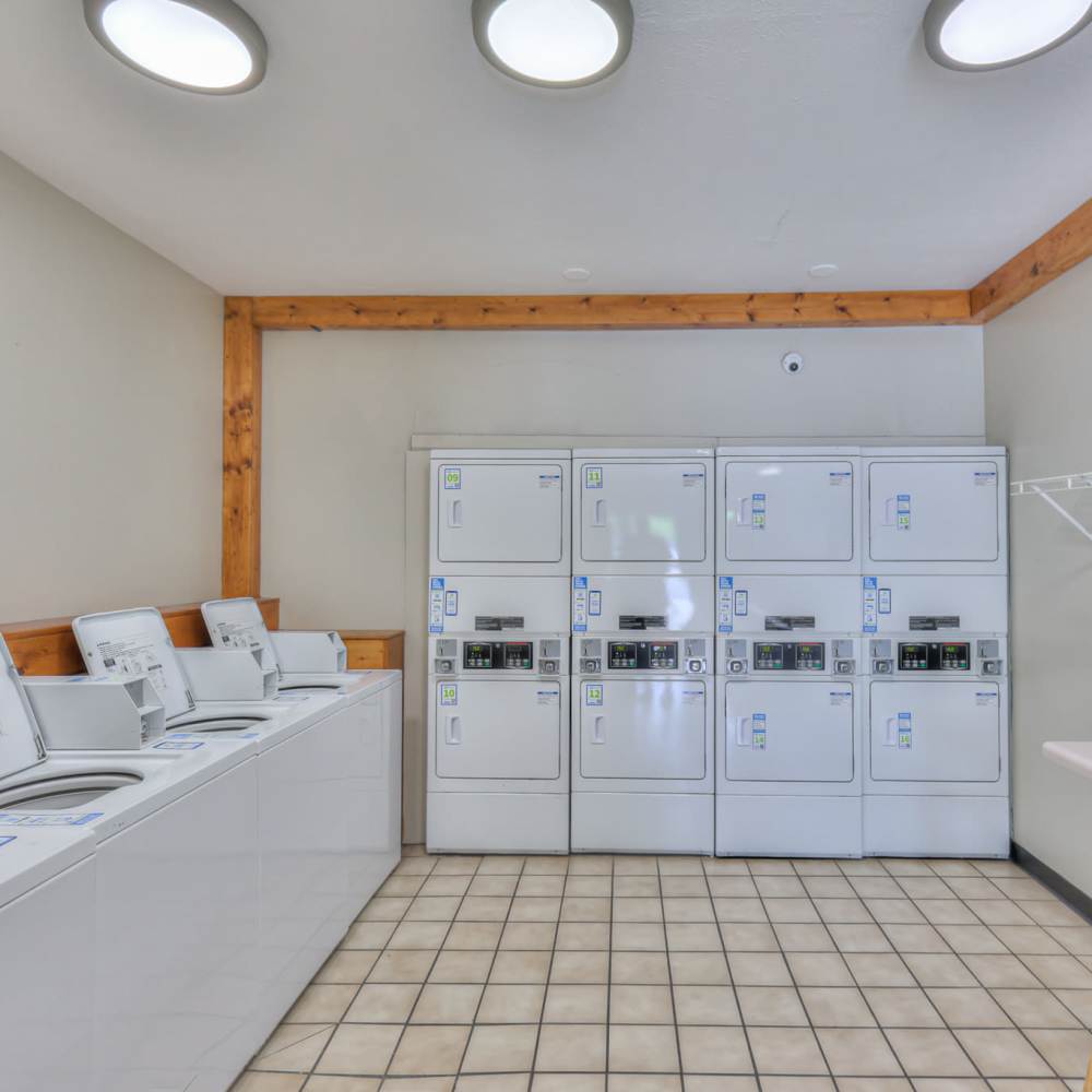 Community laundry facility with hard flooring at Village Crest Apartment Homes in Smyrna, Tennessee