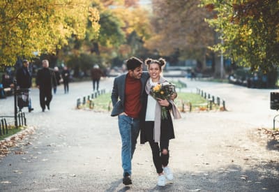 Resident couple enjoying a walk after shopping near Arvada Village Apartment Homes in Arvada, Colorado